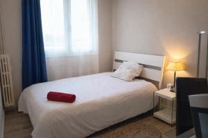 a bedroom with a bed with a red pillow on it at Chambre 3 privée lit double Béthune centre in Béthune
