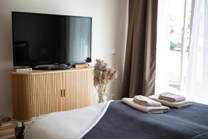 a bedroom with a tv and towels on a bed at Järvevaatega studio apartment in Viljandi