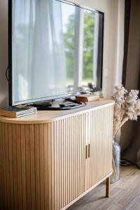 a flat screen tv sitting on top of a wooden cabinet at Järvevaatega studio apartment in Viljandi