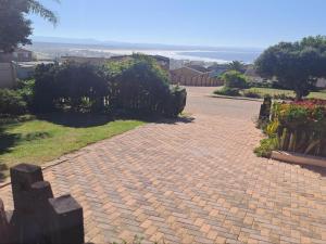 a brick walkway leading to a house with the ocean at A1Bay View Guest House Cottage & Apartment SEA FACING in Jeffreys Bay +7 photos