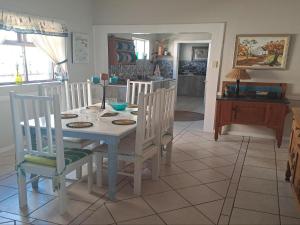 a kitchen and dining room with a table and chairs at A1Bay View Guest House Cottage & Apartment SEA FACING in Jeffreys Bay