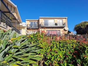 a building with a fence and plants in front of it at A1Bay View Guest House Cottage & Apartment SEA FACING in Jeffreys Bay