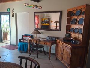 a room with a wooden desk and a mirror at A1Bay View Guest House Cottage & Apartment SEA FACING in Jeffreys Bay