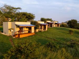 a row of houses on a hill with grass at Sunset Safari Camp at Hluhluwe Game Park in KwaNompondo
