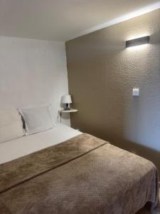 a bedroom with a bed and a light on the wall at Résidence Figarella in Propriano +63 photos
