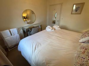 a bedroom with a large white bed with a mirror at Apartment No.1 in Lincoln
