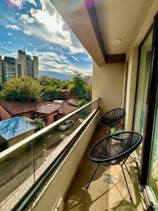 a balcony with two chairs and a view of a city at Emerald Luxury Apartments in Skopje