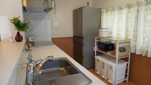 a kitchen with a sink and a refrigerator at Rabbit Island Inn in Mihara