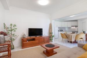 a living room with a couch and a tv at On the Beach at Amorosa in Viana do Castelo