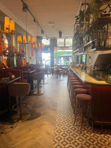 a restaurant with a bar with stools and tables at Amadeus Hotel in Haarlem