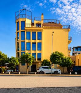a yellow building with a car parked in front of it at Хотел ЗОНАРИТА in Primorsko