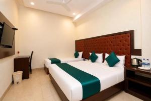 a hotel room with two beds and a television at Hotel BKC Suite in Mumbai +17 photos
