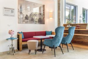 a living room with a red couch and chairs at Hotel Zur Post in Ismaning