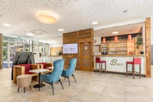 a restaurant with blue chairs and a bar at Hotel Zur Post in Ismaning