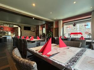 a restaurant with tables and chairs with red napkins on them at Race & Rooms Appartment in Stavelot