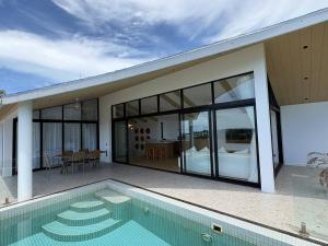 a house with a swimming pool and a patio at Villa 7 Ocean View Pool Villa in Bophut