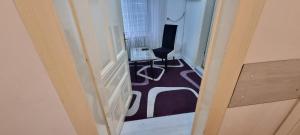 a hallway with a room with a desk and a chair at AMY APARTMAN in Tuzla