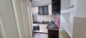 a small kitchen with a sink and a stove at AMY APARTMAN in Tuzla