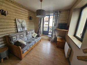 a living room with a couch in a room at Superbe appartement 2 a 6 pers. hyper cocooning in Gérardmer