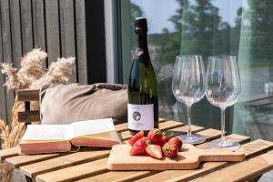 a bottle of wine and two glasses and strawberries on a table at Järvevaatega studio apartment in Viljandi
