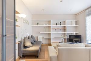 a living room with white furniture and a tv at Apartment Link BCN Sagrada Familia in Barcelona