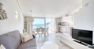 a living room with a couch and a television at Exclusive Position Front Line Apartments Calau in Calella de Palafrugell
