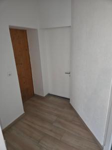 an empty room with a door and a wooden floor at Apartement with selfcatering in Buchs