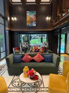 a living room with a green couch and a table at Modern Condo-Pool&Gym-ROW in Ban Rangeng