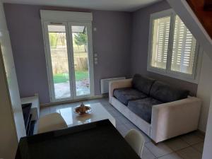 a living room with a couch and a table at Pavilion - T3 Duplex, avec Terrasse et Parking in Montagnat +1 photo