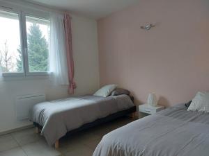 a bedroom with two beds and a window at Pavilion - T3 Duplex, avec Terrasse et Parking in Montagnat