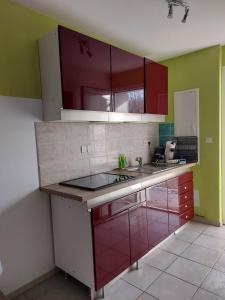a kitchen with red and green cabinets and a sink at Pavilion - T3 Duplex, avec Terrasse et Parking in Montagnat