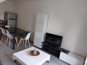 a living room with a table and a tv at Pavilion - T3 Duplex, avec Terrasse et Parking in Montagnat