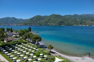 a view of a beach with umbrellas and the ocean at Park Hotel Casimiro in San Felice del Benaco