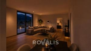 a living room with a couch and a large window at Brig Panorama Spa in Brig