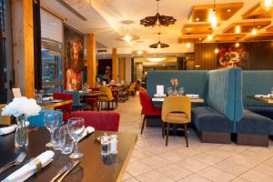 a dining room with tables and chairs and tablesktop at Logis Hotel les Sapins in Le Ménil