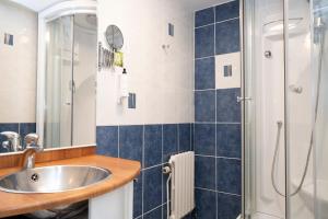 a bathroom with a sink and a shower at Logis Hotel les Sapins in Le Ménil