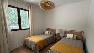 two beds in a room with a window at Finca El Carrascal Arroyo frío, Sierra de Cazorla in Arroyo Frio