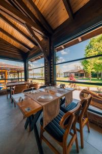 a dining room with tables and chairs and large windows at Dedeman Village Sapanca in Sakarya