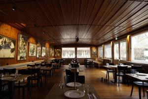 a dining room with tables and chairs and windows at Alcor Exclusive Friedrichsruh in Aumühle