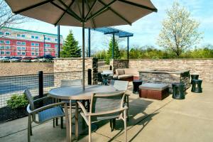 a patio with a table and chairs and an umbrella at SpringHill Suites by Marriott Buffalo Airport in Williamsville