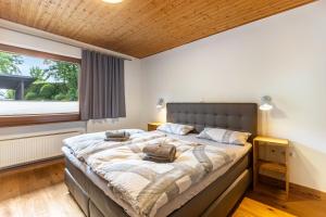 a large bed in a bedroom with a large window at Ferienhaus Rothaarblick mit Sauna in Schmallenberg