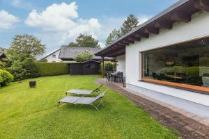 a garden with a bench on the grass at Ferienhaus Rothaarblick mit Sauna in Schmallenberg