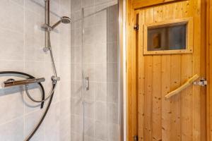 a shower with a glass door in a bathroom at Ferienhaus Rothaarblick mit Sauna in Schmallenberg +28 photos