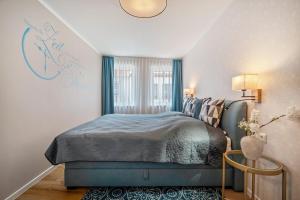 a bedroom with a blue bed and a window at Haus am See in Malchow