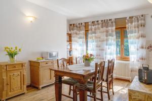 a kitchen with a wooden table and chairs in a room at Alla Loggia dell'Imperatore in Levico Terme