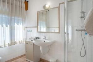 a white bathroom with a sink and a shower at Alla Loggia dell'Imperatore in Levico Terme +37 photos