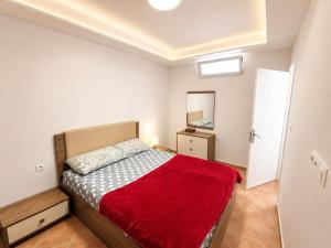 a bedroom with a bed with a red blanket at House Soleil in Agadir nʼ Aït Sa