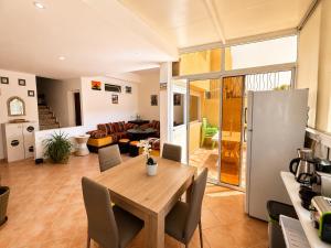 a kitchen and living room with a wooden table and chairs at House Soleil in Agadir nʼ Aït Sa