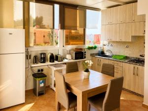a kitchen with a wooden table and a white refrigerator at House Soleil in Agadir nʼ Aït Sa +3 photos