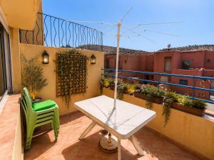a table and a green chair on a balcony at House Soleil in Agadir nʼ Aït Sa